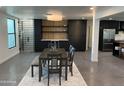 Dining area showcasing a modern bar with shelving, black cabinets, and stainless steel refrigerator at 5324 E Hillery Dr, Scottsdale, AZ 85254