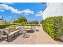 Relaxing outdoor patio space with cushioned seating surrounded by lush green hedges and mature trees at 5435 E Cambridge Ave, Phoenix, AZ 85008