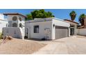 White stucco home showcasing a terracotta roof, gray garage door, and low maintenance desert landscaping at 5909 E Aire Libre Ln, Scottsdale, AZ 85254