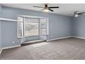 Spacious living room with a bay window and neutral carpet, lit by dual ceiling fans at 6550 W Wolf St, Phoenix, AZ 85033