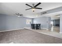 Inviting living room flows into dining area with stylish, gray accent wall and recessed lighting at 6550 W Wolf St, Phoenix, AZ 85033
