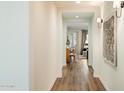 Bright hallway featuring hardwood floors, sconces, and artwork, leading to the living area at 6954 W Maya Way, Peoria, AZ 85383