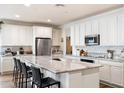Bright kitchen features white cabinetry, granite countertops, stainless appliances and a large island with seating at 6954 W Maya Way, Peoria, AZ 85383