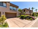 Townhome showcases a two-car garage with lush landscaping, a well-maintained driveway, and a sunny day at 7400 E Gainey Club Dr # 203, Scottsdale, AZ 85258