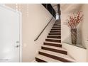Elegant staircase with marble steps, a dark wood trim, and decorative vase at the landing at 7400 E Gainey Club Dr # 203, Scottsdale, AZ 85258