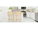 Modern kitchen featuring stainless steel appliances, white cabinets, and an island with seating at 9541 W Pinchot Ave, Phoenix, AZ 85037