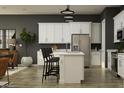 Bright kitchen featuring white cabinets, stainless steel appliances, and an island with seating at 9633 W Monterey Way, Phoenix, AZ 85037