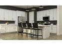 Modern kitchen features white cabinets, stainless steel appliances, and a central island with seating at 9633 W Monterey Way, Phoenix, AZ 85037
