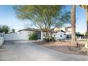 Exterior side view of the home showing rock landscaping, gated driveway, and mature trees at 1512 E Cypress St, Phoenix, AZ 85006