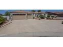 Attractive desert home featuring a large concrete driveway and two-car garage at 17770 N 66Th Ln, Glendale, AZ 85308