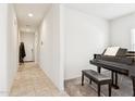 Hallway leading to the main door and a room with a piano and a bench at 18333 N Presley Ln, Maricopa, AZ 85138