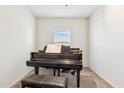 A grand piano, a bench, and a window in a small, carpeted room at 18333 N Presley Ln, Maricopa, AZ 85138