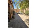 Cozy backyard featuring a brick patio, seating area, and mature trees providing shade at 2125 E Danbury Rd, Phoenix, AZ 85022