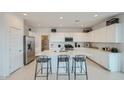 Bright modern kitchen boasts white cabinets, stainless appliances, and island seating at 24962 N 174Th Ave, Surprise, AZ 85387