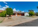 Charming single-story brick home featuring a spacious driveway, mature landscaping, and a well-maintained front yard at 3126 W Stella Ln, Phoenix, AZ 85017