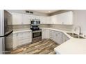 Modern kitchen with white cabinets, stainless steel appliances, and quartz countertops at 4833 N 63Rd Ln, Phoenix, AZ 85033