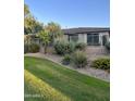 Private backyard features a green lawn, mature trees, and metal fencing at 7052 E Kessler Ave, Mesa, AZ 85209