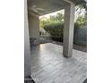Covered patio with neutral-toned tile flooring and desert landscaping views at 7052 E Kessler Ave, Mesa, AZ 85209