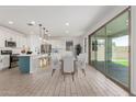 Open-concept kitchen and dining area with a center island and sliding glass doors at 7413 S 32Nd Dr, Phoenix, AZ 85041