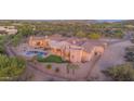 Stunning custom home with a backyard pool and spiral staircase in a desert landscape with mountain views at 8024 E Lone Mountain Rd, Scottsdale, AZ 85266