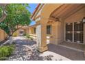 Inviting arched entrance with a neutral stucco exterior and desert landscaping surrounding the entryway at 9797 N 100Th Pl, Scottsdale, AZ 85258