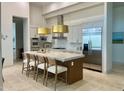 Bright kitchen featuring an island with seating, stainless appliances, and modern lighting at 10821 E Troon North Dr, Scottsdale, AZ 85262