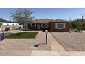 Charming single-story brick home with low-maintenance gravel landscaping and a green artificial lawn at 1721 W Earll Dr, Phoenix, AZ 85015