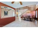 Inviting dining room featuring tile floors, decorative chandelier, and a stairway to the second floor at 18182 W Desert Ln, Surprise, AZ 85388