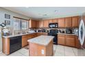 Well-equipped kitchen with granite countertops, wood cabinets, tile backsplash, and modern appliances at 18182 W Desert Ln, Surprise, AZ 85388