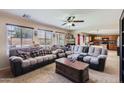 Comfortable living room with a plush sectional sofa, ceiling fan, and plenty of natural light at 18182 W Desert Ln, Surprise, AZ 85388