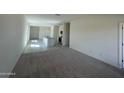 Open-concept living room and kitchen area with neutral carpet and tile flooring at 1907 E Bucking Bronco Dr, San Tan Valley, AZ 85140