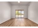 Bright bedroom featuring new flooring, ceiling fan, and sliding glass doors to an outdoor patio at 19621 W Minnezona Ave, Litchfield Park, AZ 85340