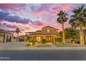 Inviting home exterior at sunset with illuminated palm trees and well-manicured landscaping at 21575 E Twin Acres Ct, Queen Creek, AZ 85142