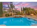 Sparkling pool with a built-in spa, surrounded by lush landscaping and cozy outdoor seating at 21575 E Twin Acres Ct, Queen Creek, AZ 85142