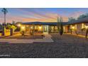 View of the home's exterior showcasing the desert landscape, rock yard, and modern design with the sun setting at 22039 N 86Th Ave, Peoria, AZ 85383