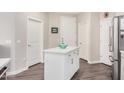 Kitchen island with white cabinets and light countertop adjacent to 3 entry doors at 2511 W Queen Creek Rd # 258, Chandler, AZ 85248