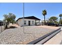 Quaint home featuring desert landscaping, a covered carport, and a driveway for parking at 2815 W Ohio St, Apache Junction, AZ 85120