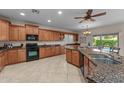 Spacious kitchen with granite countertops, wood cabinets, tile flooring, island, and stainless steel appliances at 3018 E Vernon St, Gilbert, AZ 85298