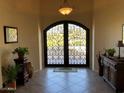 Grand foyer featuring a decorative wrought iron front door and neutral tile flooring at 35401 N Via Tramonto St, Phoenix, AZ 85086