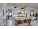 Stunning kitchen with white cabinets, an island with seating, and modern pendant lighting at 6190 N Sunrise Ln, Buckeye, AZ 85396
