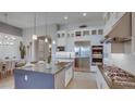 Beautiful, bright kitchen featuring stainless steel appliances, pendant lights, and a central island at 6190 N Sunrise Ln, Buckeye, AZ 85396