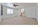 Bright living room with carpet, a ceiling fan, and a staircase leading to the upper level at 6843 S 9Th Ave, Phoenix, AZ 85041