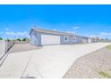 Well-maintained single-story home with an extended driveway and gated entrance for privacy at 12938 W Tara Ln, Surprise, AZ 85374