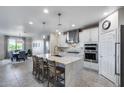Modern kitchen features white cabinetry, stainless steel appliances, a large island and barstool seating at 13237 W Redstone Dr, Peoria, AZ 85383