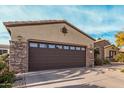 Spacious two car garage with beautiful stone accents and desert landscaping at 15452 W Skyview Way, Surprise, AZ 85374