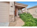 Inviting home entrance with stone accents, a paved walkway, and lush greenery surrounding the front door at 15634 S 31St St, Phoenix, AZ 85048