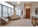 Bright living room featuring large windows with plantation shutters, neutral colors, and tiled entryway at 15634 S 31St St, Phoenix, AZ 85048