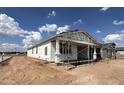 Newly built home with wrapped exterior, showcasing a modern design in a neighborhood under construction at 15794 W Cheryl Dr, Waddell, AZ 85355
