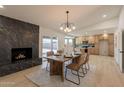 Open concept dining room featuring a stone fireplace and modern lighting and access to kitchen at 1609 W Yukon Dr, Phoenix, AZ 85027