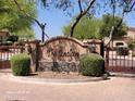 Welcoming gated community entrance with manicured landscaping and an attractive sign reading 
